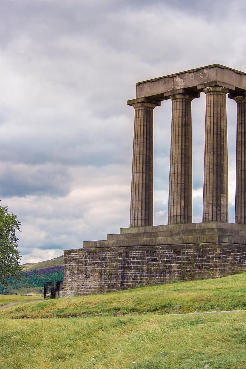 The stone colonnade of the National Monument on Calton Hill, Edinburgh, standing on a grassy rise.
